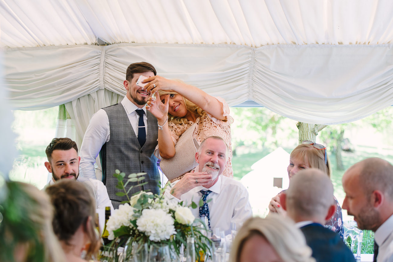 Wedding guest taking a selfie with the groom 