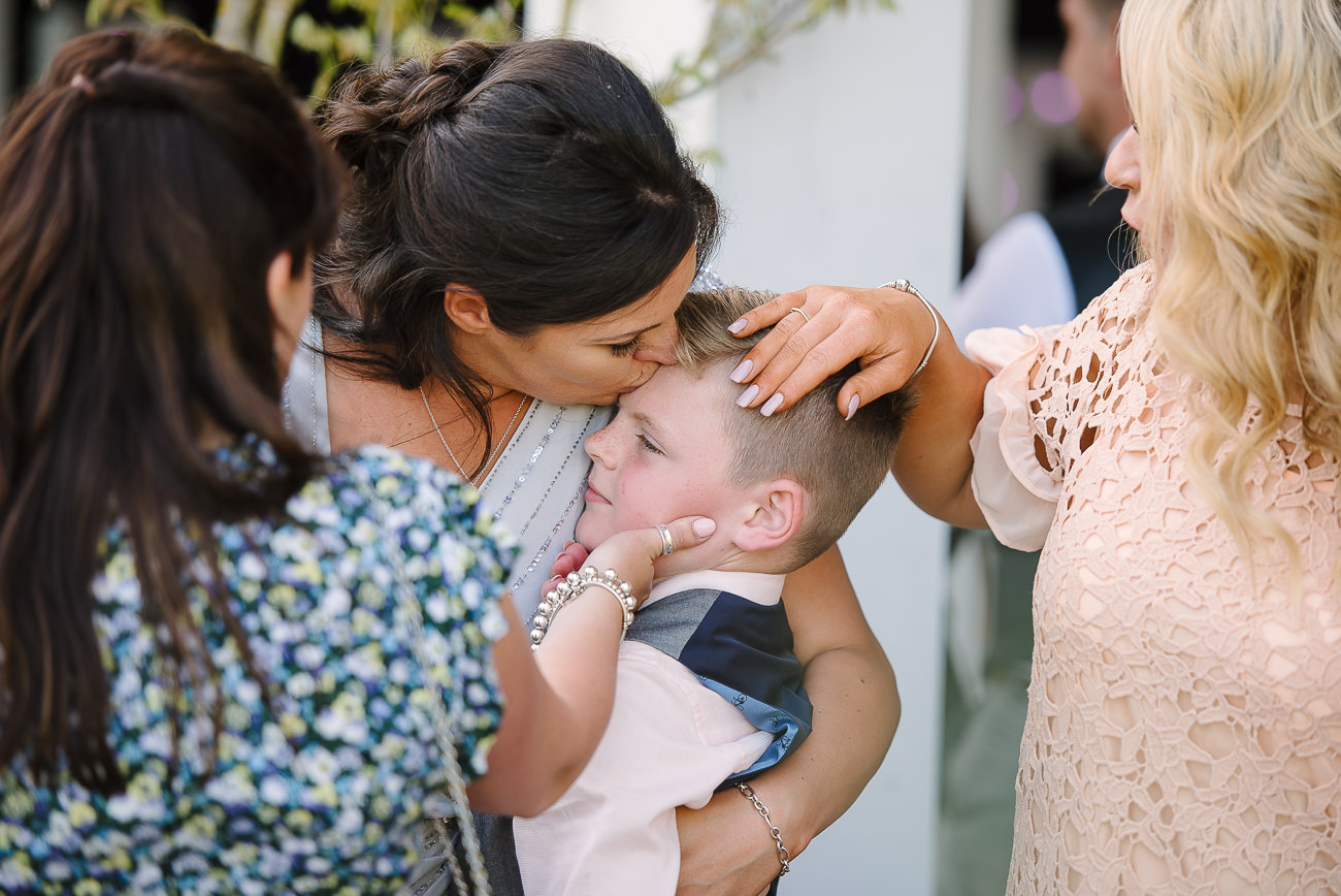 Woman kissing boy on the forehead