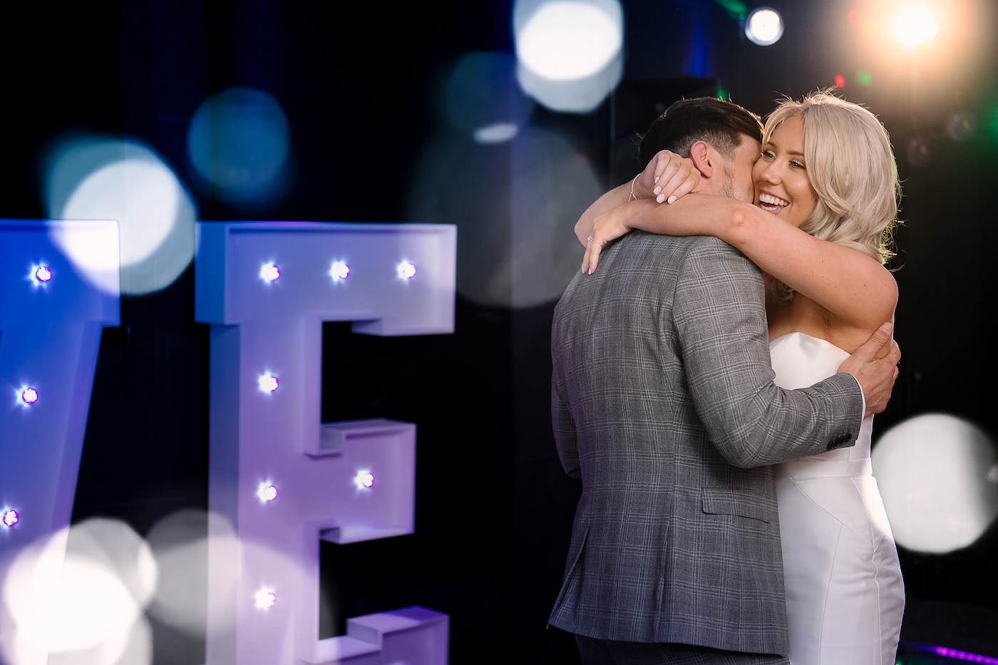 Bride and groom dancing on the dance floor in a tight embrace 