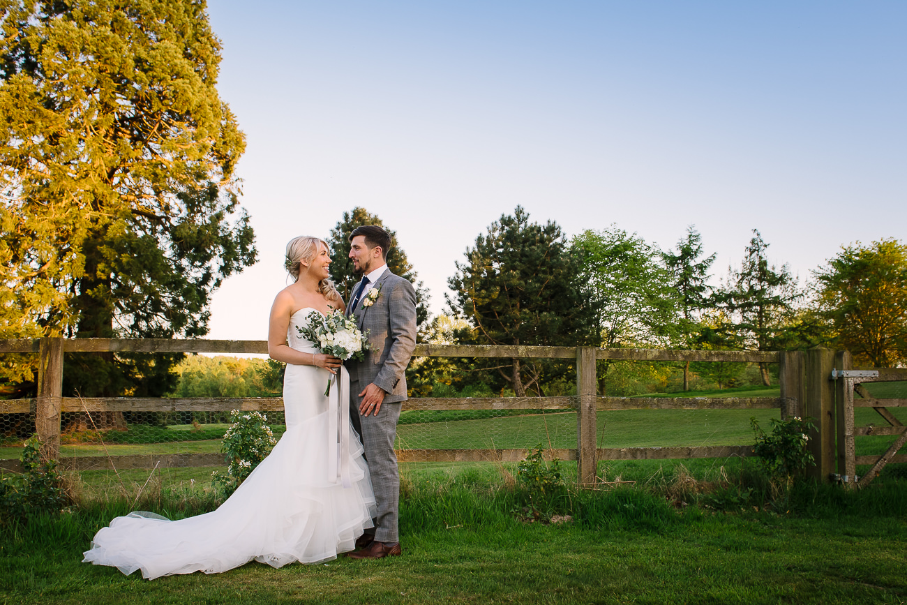 Bride with bouquet and groom lovingly looking at each other 