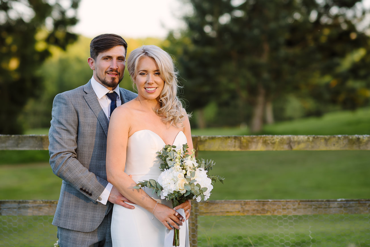 Bride with bouquet and groom standing close and posing at Russets Country House