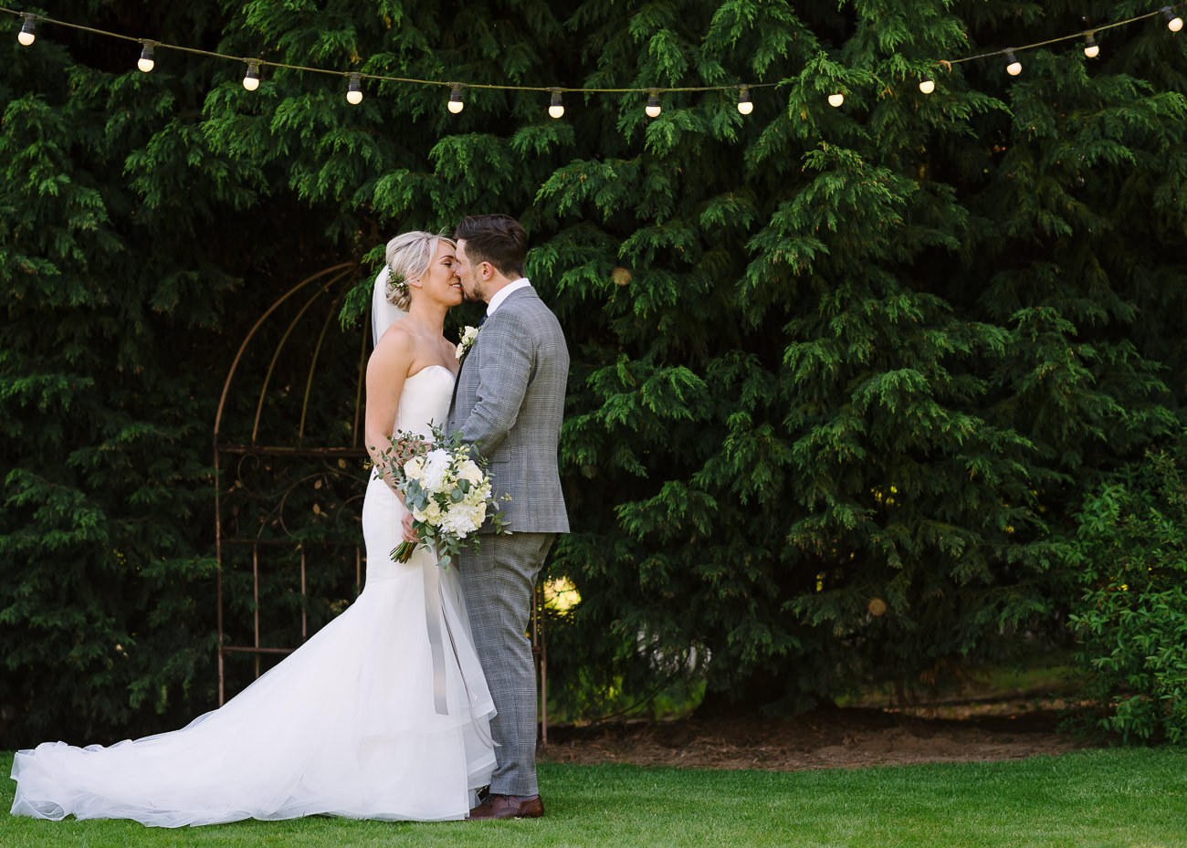 Bride with bouquet and groom kissing portrait at Russets Country House