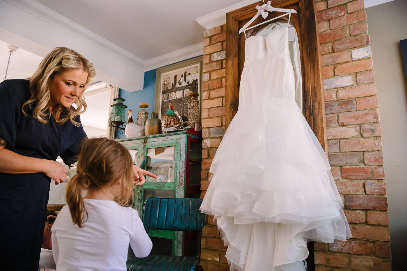 Flower girl is being shown the wedding dress 