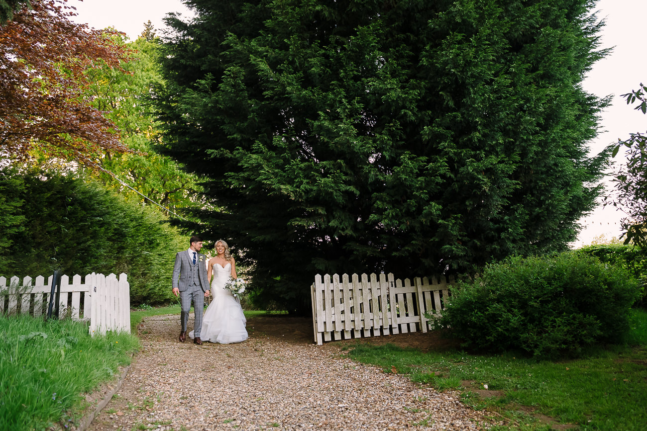 Bride and groom holding hands and walking through the grounds at Russets Country House