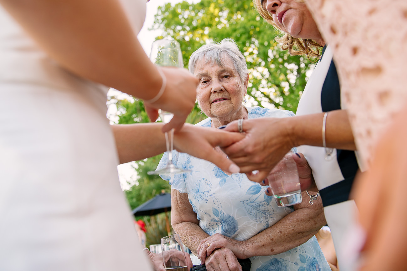 Grandmother looking at brides ring on the finger 