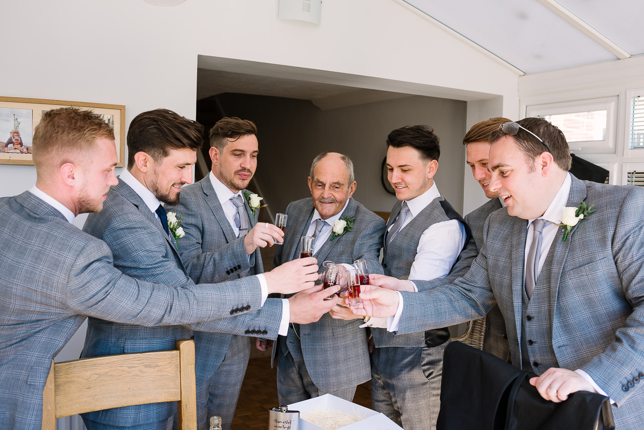 Groom and groomsmen having a toast before they leave to ceremony