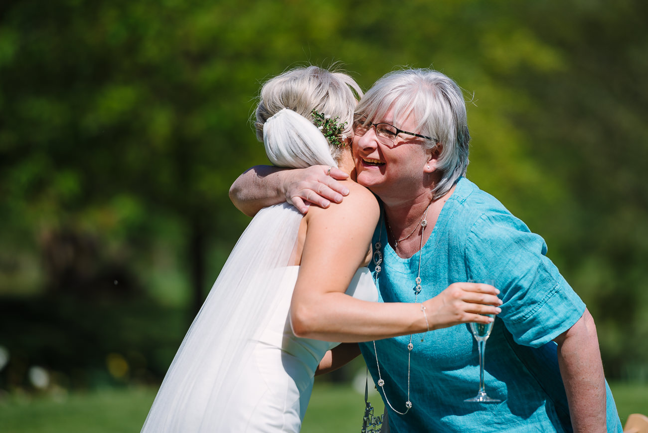 Russets country house owners hugging the bride on the lawn