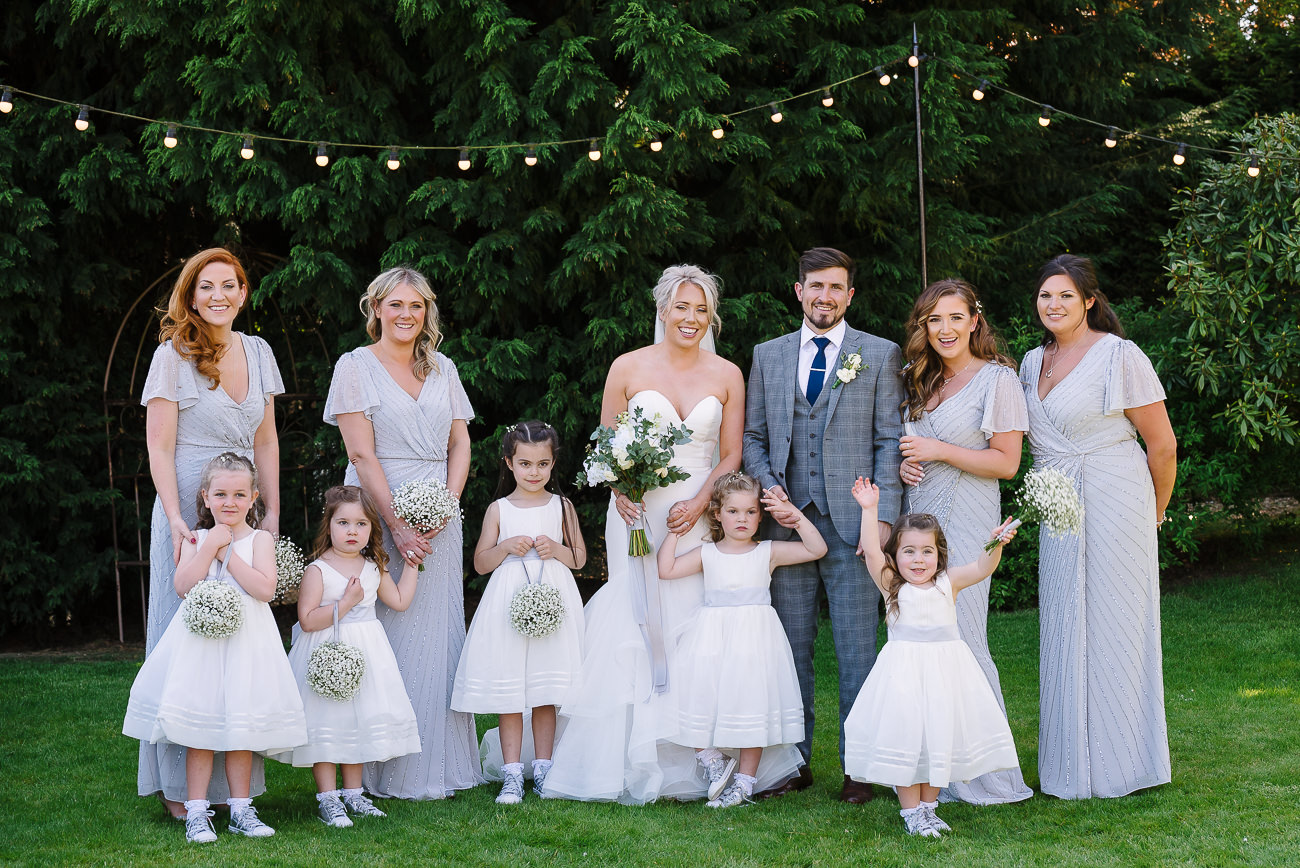 Bridesmaids with flower girls along with bride and groom group photography