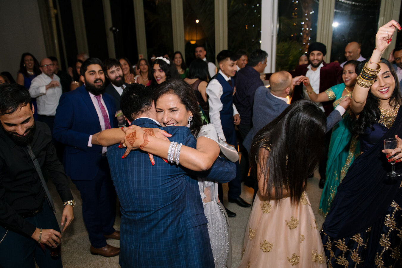 Sikh Asian wedding guests are dancing and feeling happy on the dance stage at Hampton Court House.