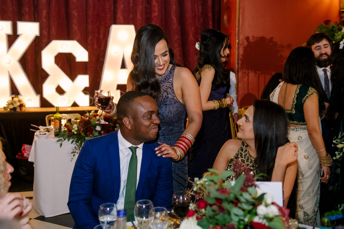 Asian wedding bride is chatting with her guests at their tables