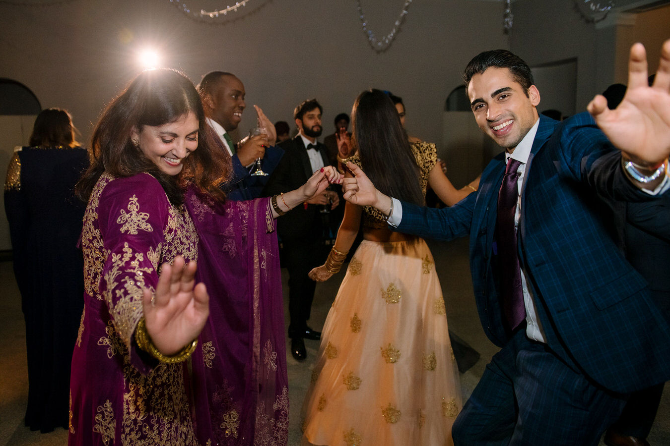 Wedding guests are dancing and feeling good at the Sikh Asian wedding.