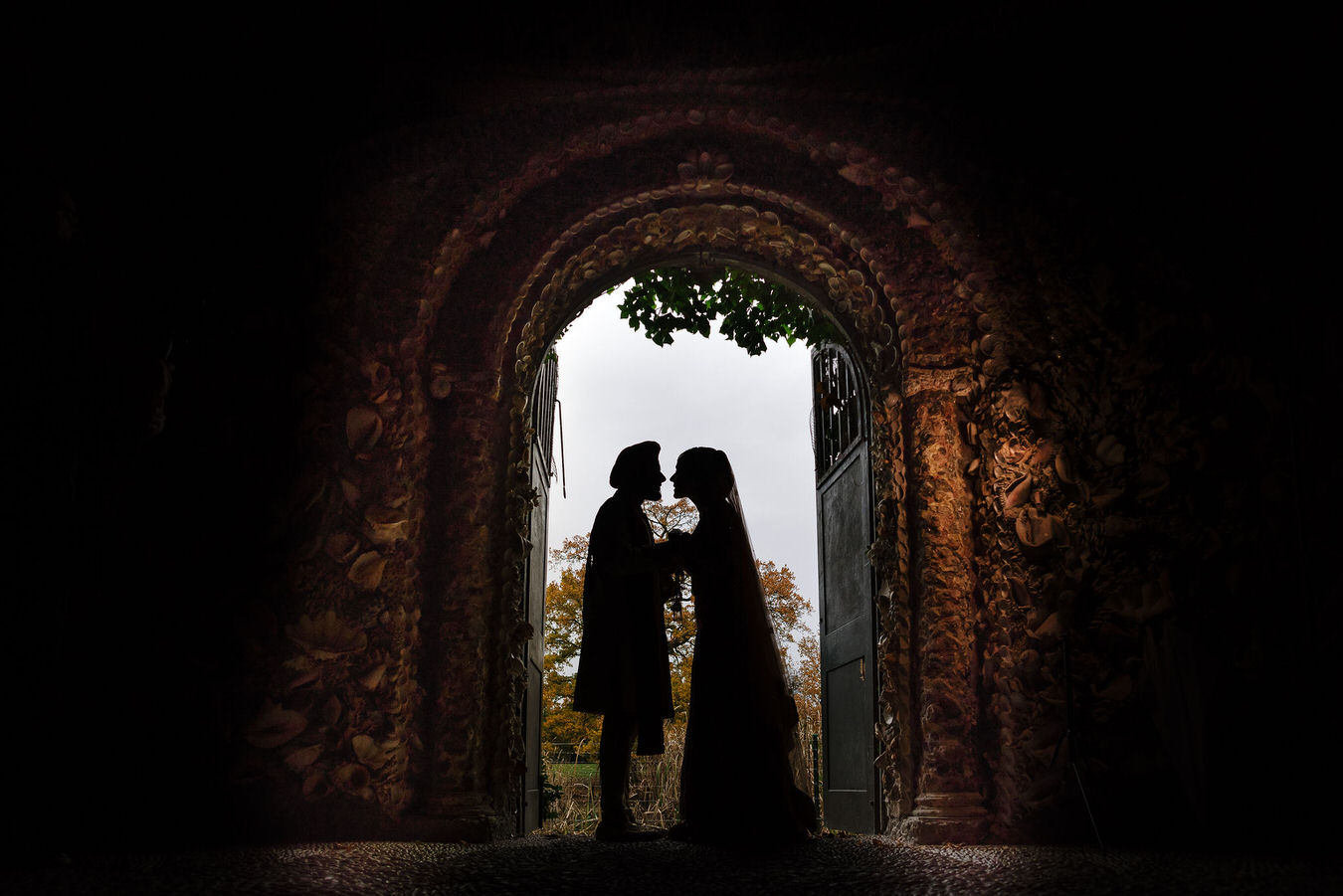 Wedding photography silhouette of bride and groom standing inside the grotto at Hampton Court House