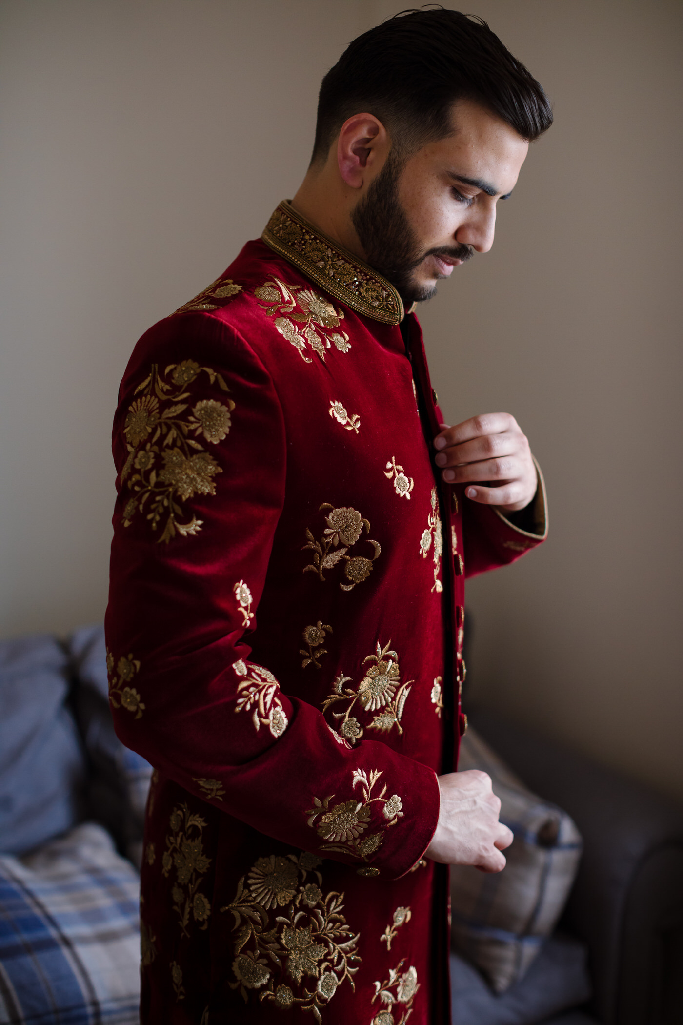 Wedding photography with muslim groom dressed in red sherwani with flowers embroidery