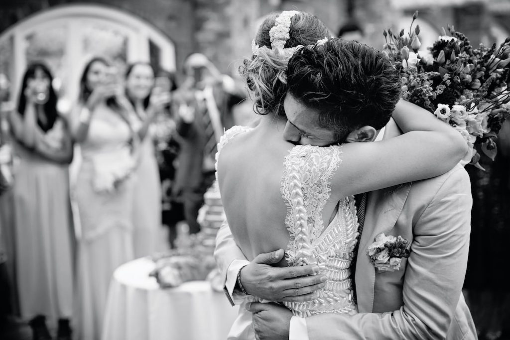 Bride and groom hug in front of their guests