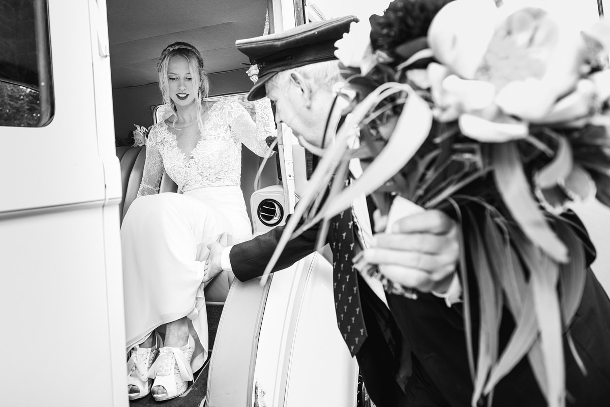 Bride getting out of bridal car at Canford Parish Church