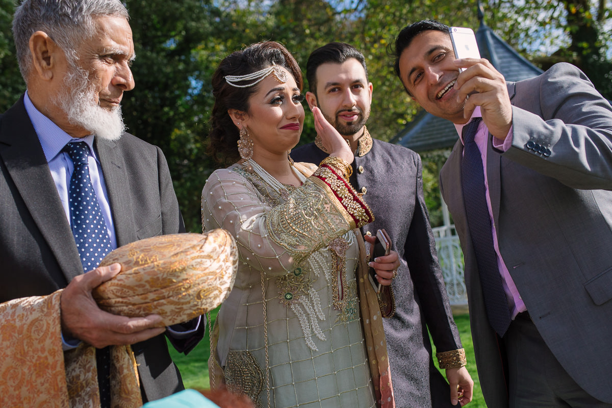 Photography of relatives calling at Asian wedding at Alton House Hotel