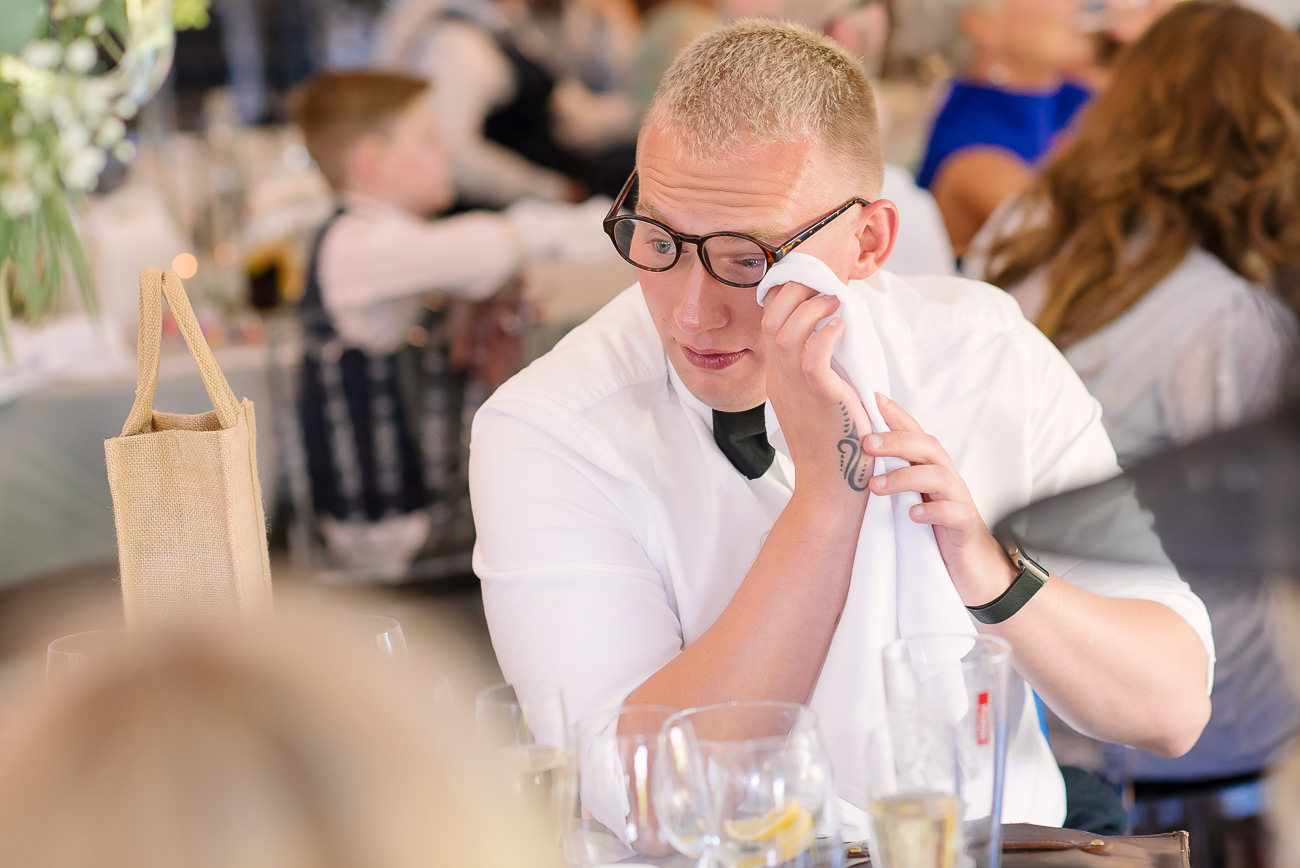 Wedding guest wiping a tear off at speeches 