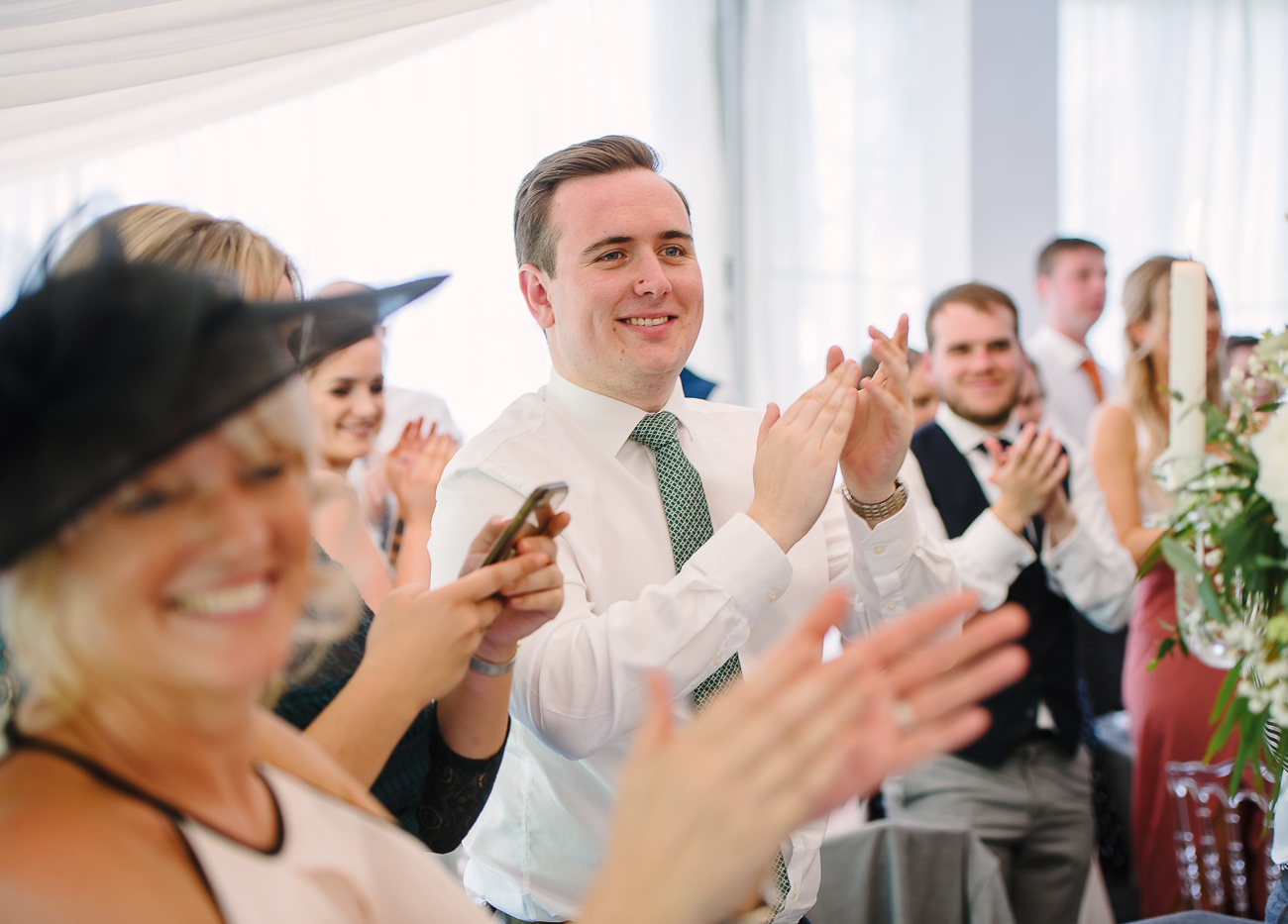 Wedding guests clapping hands for bride and groom entrance 