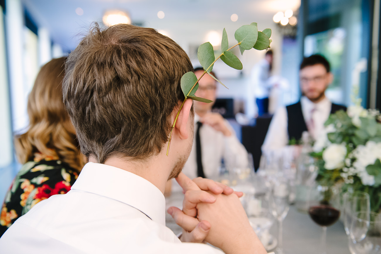 Man with a eucalyptus twig over the right ear 