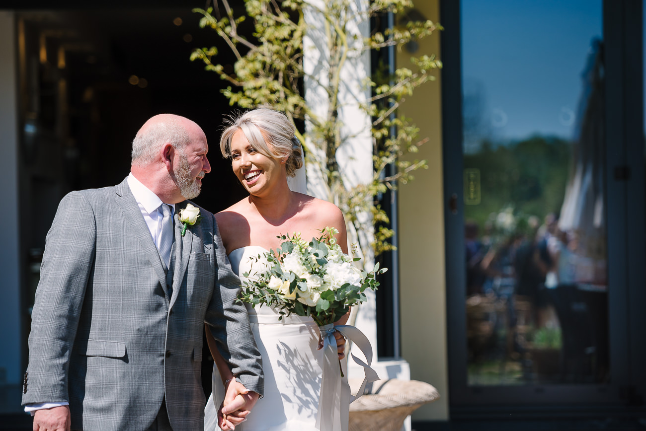 Bride holding hand with her dad looking in each others eyes