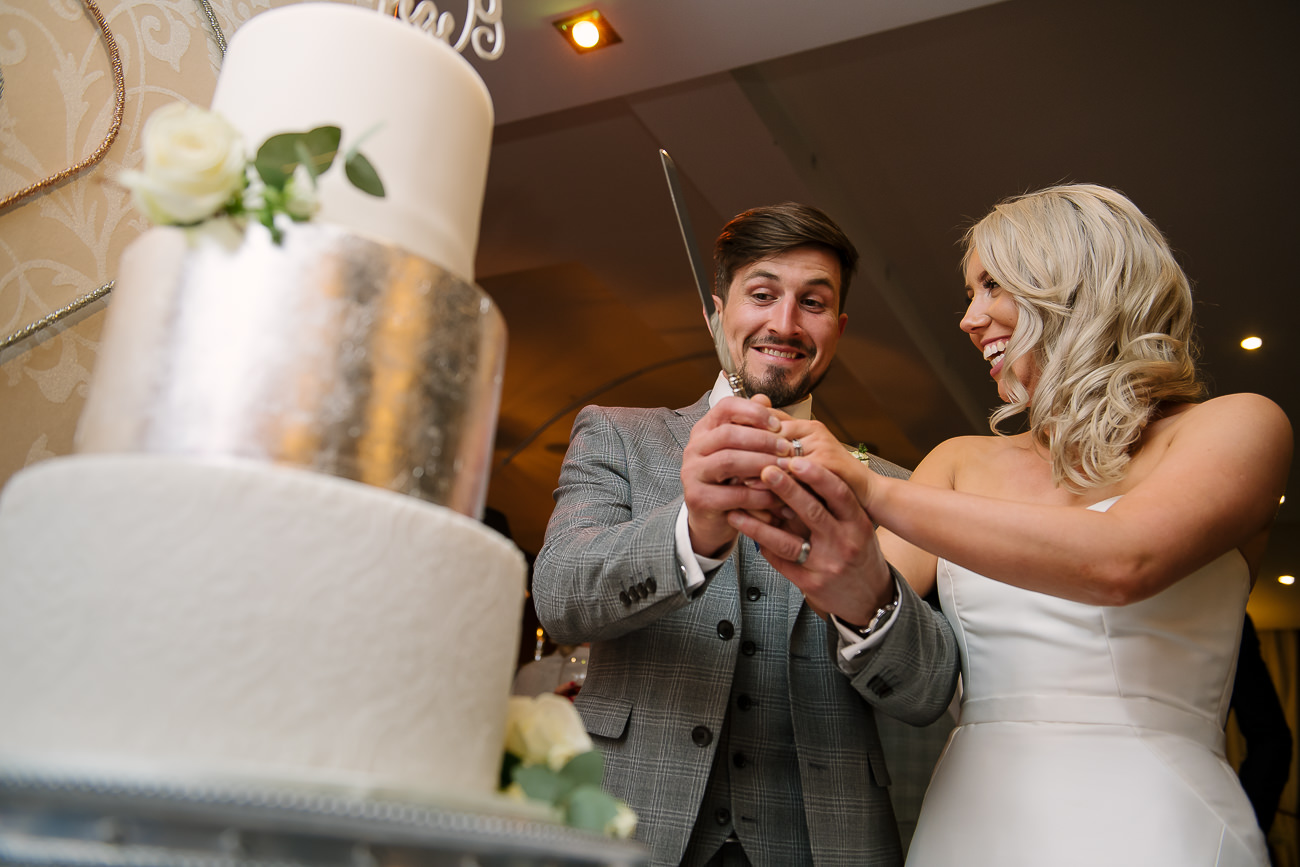 Bride and groom preparing to cut a big cake in front of the guests at Russets Country House