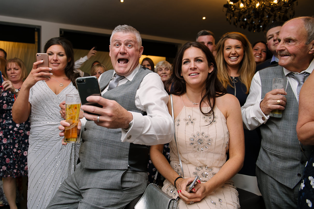 Guest taking pictures of the bride and groom as they cut the cake at Russets Country House 