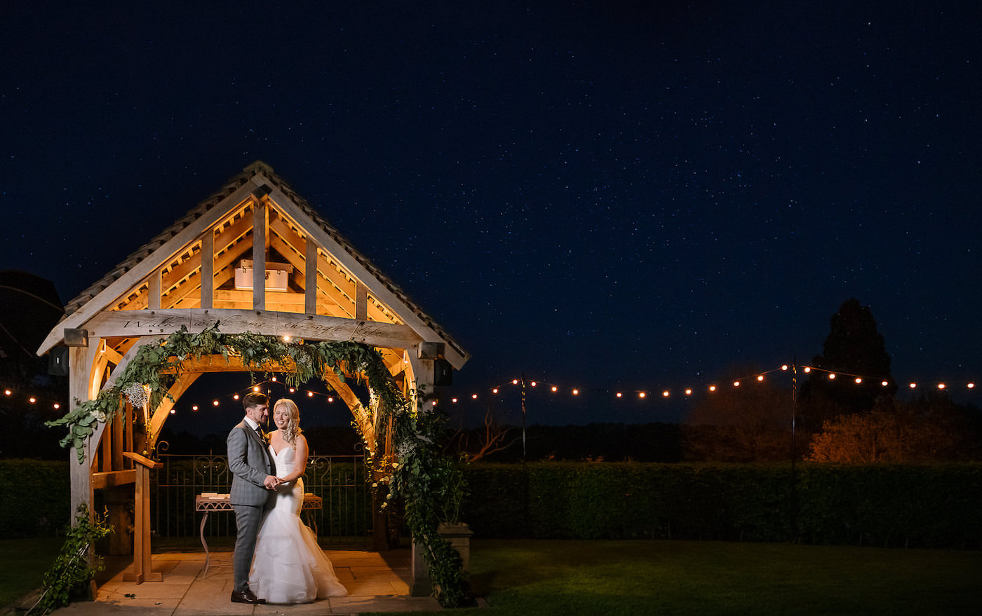 Night time portrait of bride and groom with festoon lights at Russets Country House 