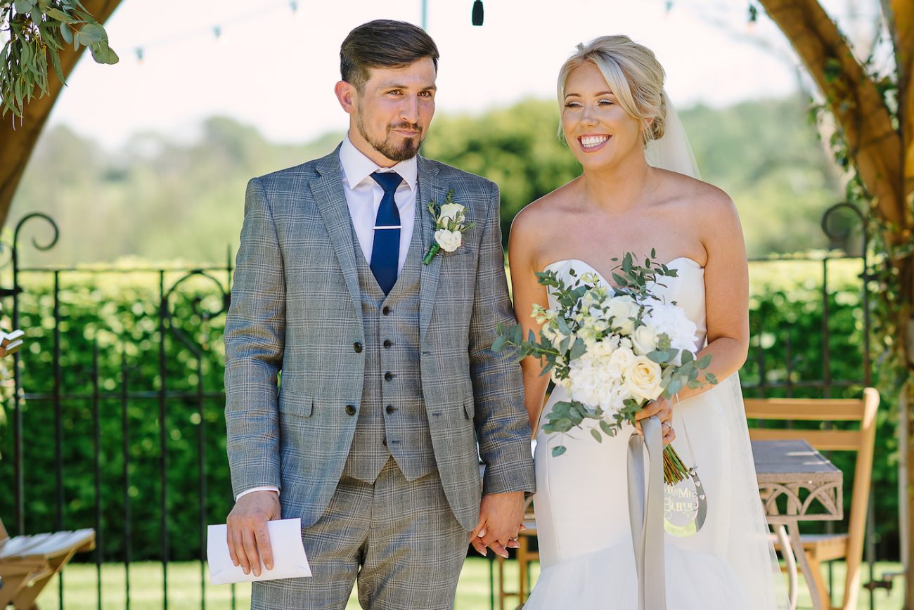 Bride and groom holding their marriage certificate at Russets Country House