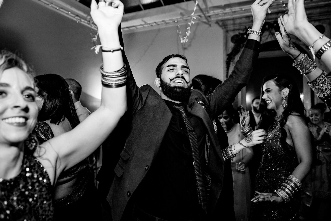Asian wedding guests feel good dancing with the hands up and singing