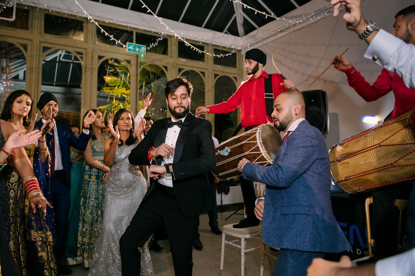 Groom and the wedding guests are moving in the rhythm of the Indian music at Hampton Court House