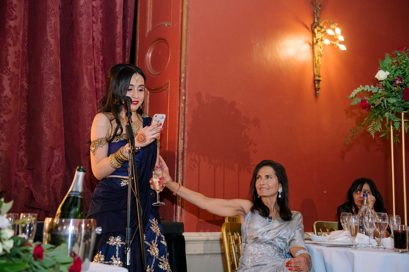 Bride’s sister is finishing her speech encouraged by her mother holding her hand.