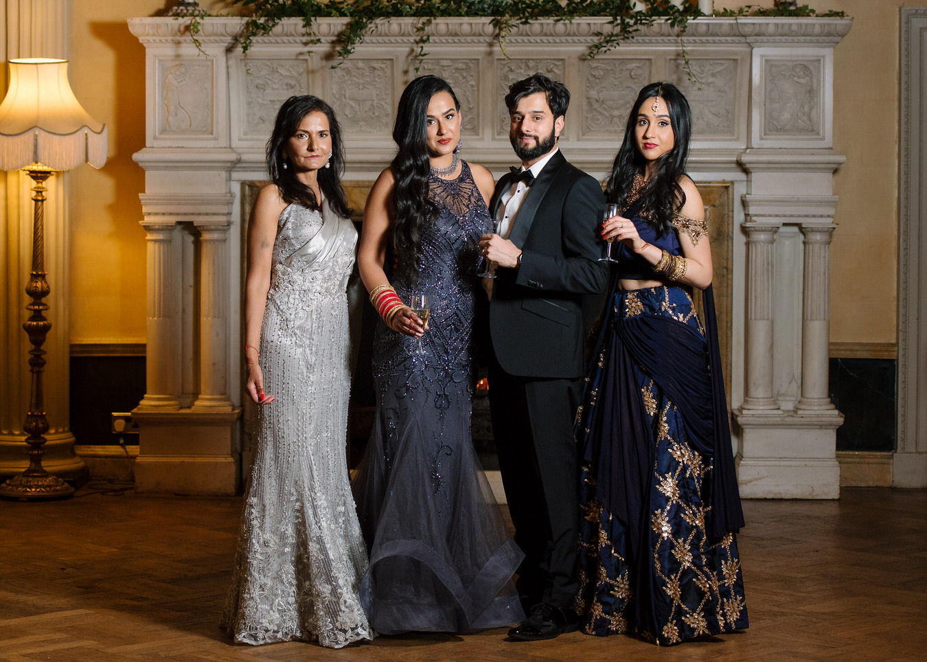 Sikh Asian wedding family photography portrait with mother of the bride dressed in sparkling grey evening dress and sister’s bride on the right

