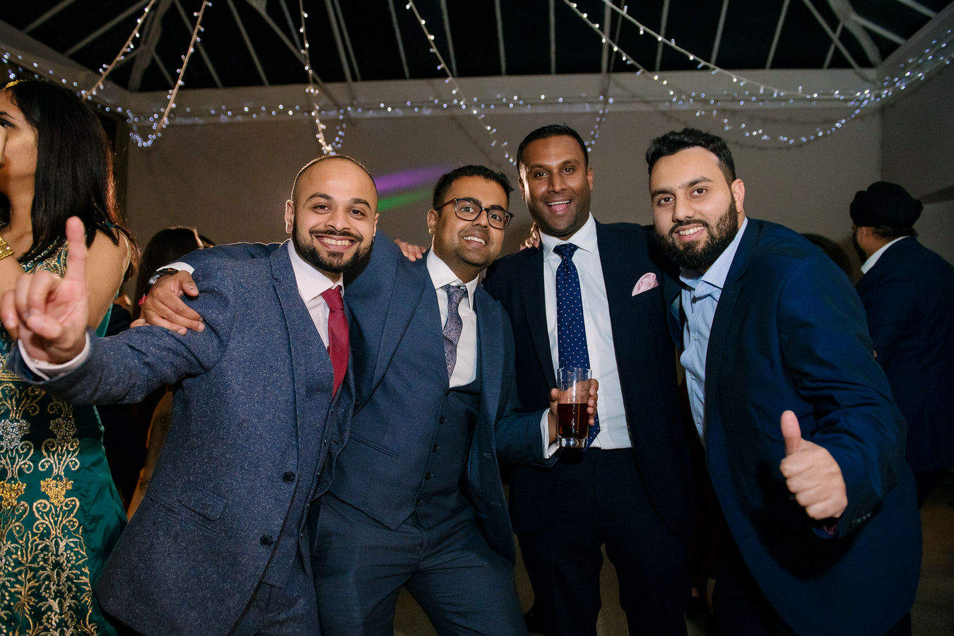 Wedding guests at an Asian wedding are having a group photo.