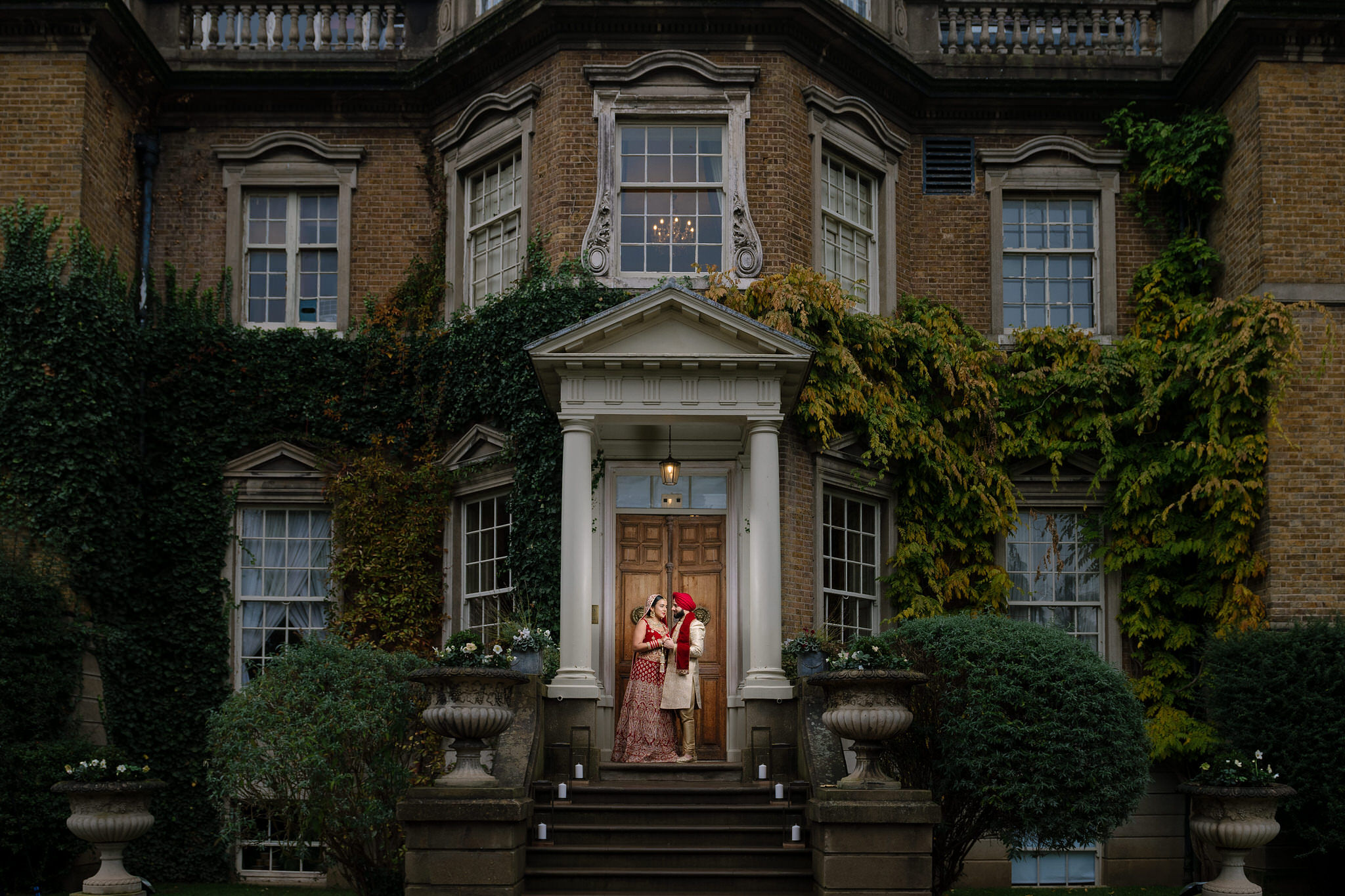 Wedding photography Asian bride & groom in front of Hampton Court House