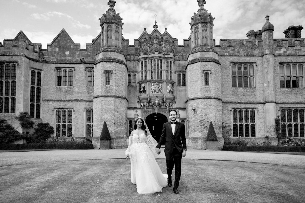 Couple walking hand in hand on their wedding day at Hengrave hall